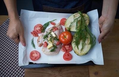 Cropped image of hands holding food plate