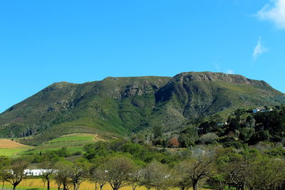 Scenic view of mountains against clear blue sky