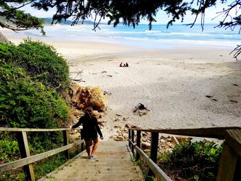 Rear view of woman walking on beach