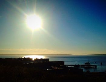 Sun shining through clouds over sea