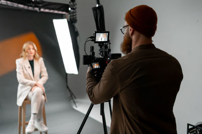 Man captures woman in film studio set.