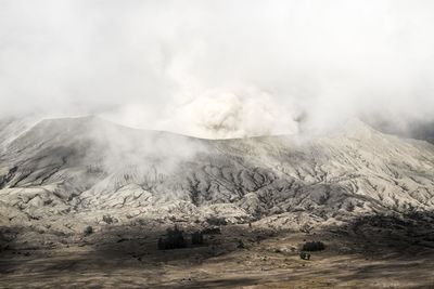 Smoke emitting from volcanic mountain against sky