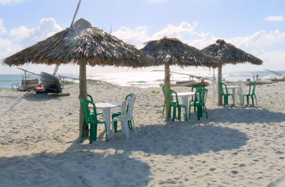 Chairs on beach against sky