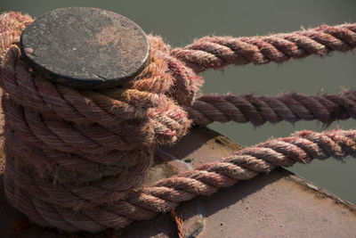 Close-up of rope tied on bollard on pier