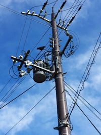 Low angle view of power lines against blue sky