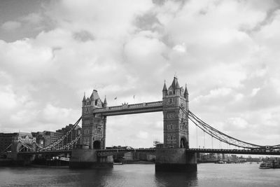 Bridge over river against cloudy sky