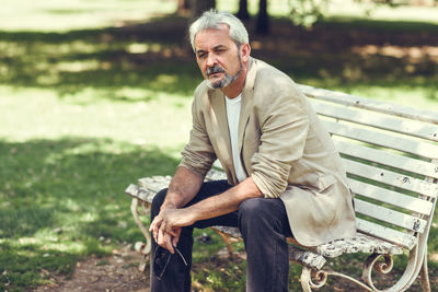 Mature man sitting on bench at park