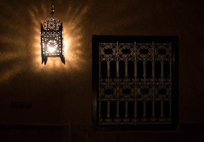 Low angle view of illuminated light bulb hanging at home
