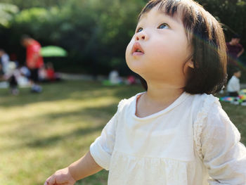 Portrait of cute baby girl looking away outdoors