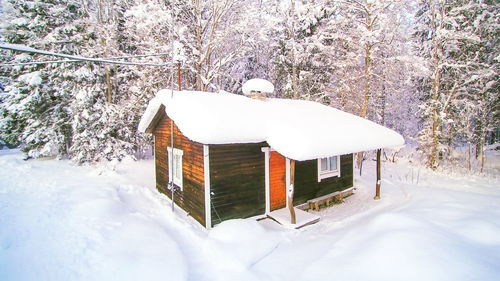 Snow covered field by building