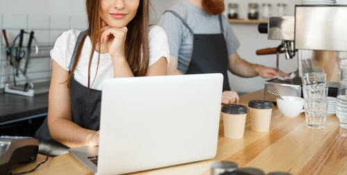 Midsection of woman using laptop on table