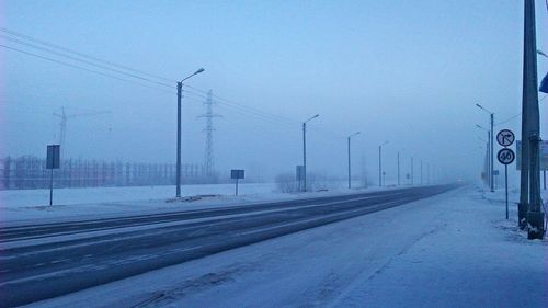 Snow covered road against sky