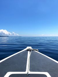 Close-up of boat sailing in sea against blue sky