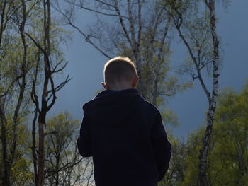 Rear view of man standing in forest