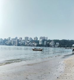 Scenic view of sea and buildings against clear sky