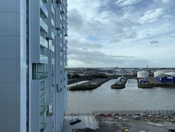 Scenic view of sea by buildings against sky