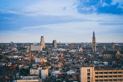 Aerial view of city against cloudy sky