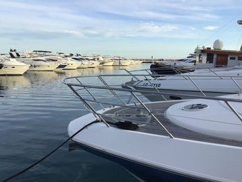 Sailboats moored in marina against sky