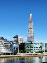 Buildings in city against blue sky