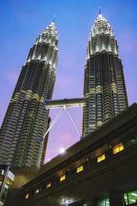 Low angle view of illuminated buildings against sky in city