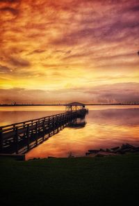 Pier on sea against sky during sunset