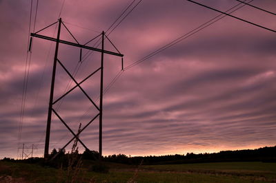 Silhouette electricity pylon on field against sky at sunset