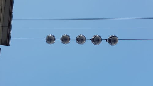 Low angle view of cables against clear blue sky