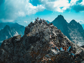 Group of people on rock against sky