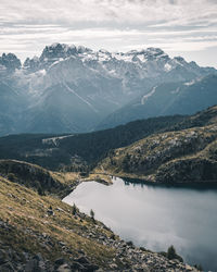 Scenic view of lake by mountains against sky