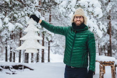 Woman standing on snow covered tree