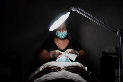 Portrait of woman holding illuminated electric lamp