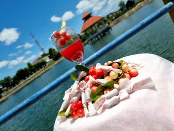 Close-up of fruits in water at swimming pool against sky