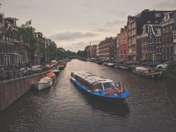 Boats moored in city against sky