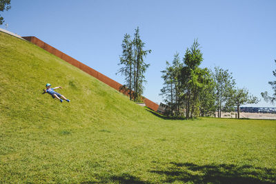 Man on green field against clear sky