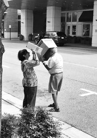 Full length of a man holding woman standing in city