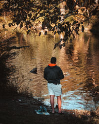 Rear view of man walking by lake