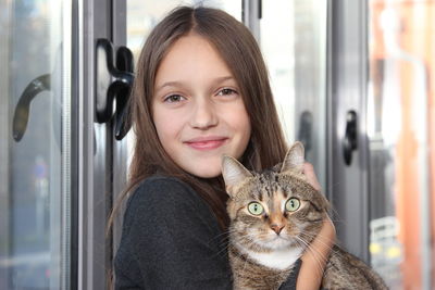 Portrait of smiling girl with cat