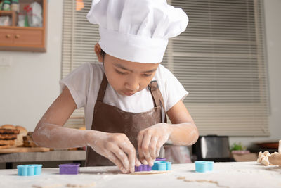 Rear view of boy looking at table