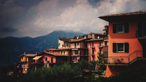 Houses by buildings in town against sky at dusk
