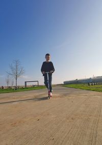 Full length of man standing on field against clear sky