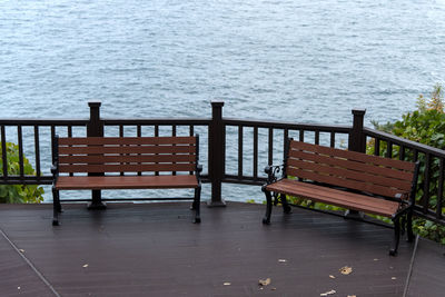 Empty chairs and table by sea