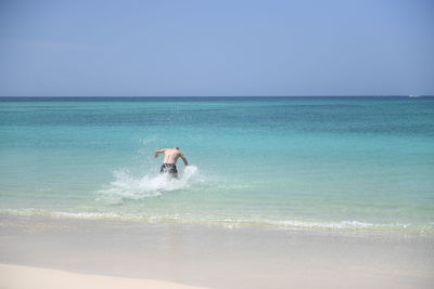 Woman in sea against sky