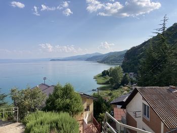 High angle view of houses by sea against sky