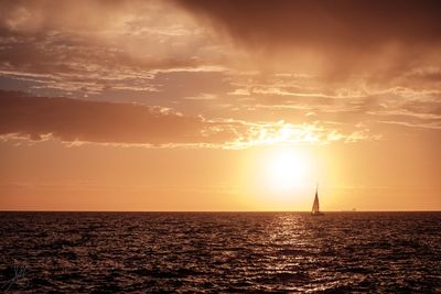 Silhouette boat on sea against sky during sunset