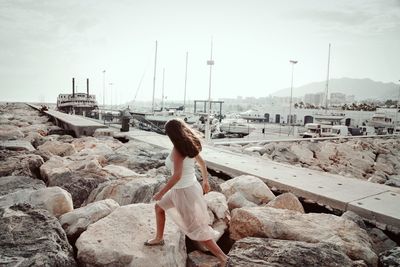 Side view full length of woman walking on rocks