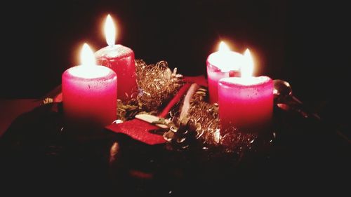 Close-up of lit candle in dark room