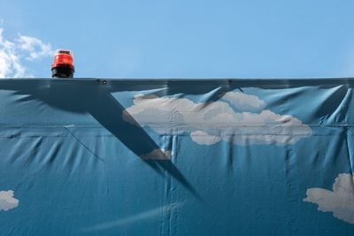 Low section of man against blue sky