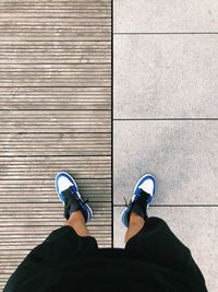 Low section of man standing on tiled floor