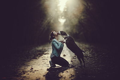 Rear view of couple kissing on road at night