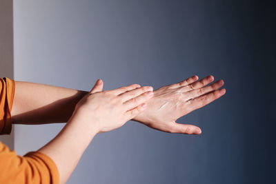 Hands of a young woman gently rub with a cream from dryness and moisturize and nourish the skin